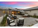 Outdoor seating area with patio furniture, umbrellas, brick paving, and manicured landscaping at 12365 E Gold Dust Ave, Scottsdale, AZ 85259