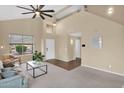 Comfortable living room showcasing neutral tones, high ceilings, a ceiling fan and large windows for natural light at 13641 W Solano Dr, Litchfield Park, AZ 85340