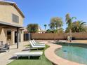 Relaxing backyard oasis with sparkling pool, lounge chairs, and lush landscaping perfect for entertaining at 13641 W Solano Dr, Litchfield Park, AZ 85340