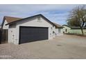 Exterior view of attached garage with dark gray door and desert landscaping at 1511 N Kadota Ave, Casa Grande, AZ 85122