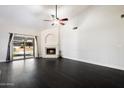 Light-filled living room boasts fireplace, ceiling fan, and sliding doors that offer an abundance of natural light at 15764 W Shiloh Ave, Goodyear, AZ 85338