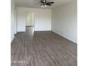 Bright living room features sleek wood floors, white painted brick wall, and a modern ceiling fan at 1853 W Burgess Ln, Phoenix, AZ 85041