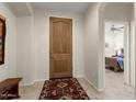Inviting foyer featuring a wood door and tiled floor at 26234 W Matthew Dr, Buckeye, AZ 85396