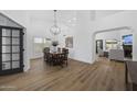 Elegant dining room featuring a modern chandelier, wood floors, and views of the living room at 567 W Laredo Ave, Gilbert, AZ 85233