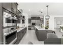 Well-equipped kitchen with sleek appliances, gray cabinetry, a center island, and stylish pendant lighting at 7259 S 221St Ave, Buckeye, AZ 85326
