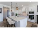 Modern kitchen featuring a large island with seating, stainless steel appliances, and pendant lighting at 7271 S 221St Ave, Buckeye, AZ 85326