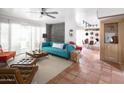 Bright living room featuring a stylish teal couch, terracotta tile floors, and mid-century modern furniture at 7740 E Heatherbrae Ave # 5, Scottsdale, AZ 85251