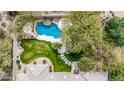Aerial view features a private backyard with a lush lawn, pool with water feature, and stone path at 7829 E Softwind Dr, Scottsdale, AZ 85255