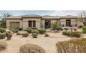 Charming single story home with neutral colors and lush xeriscape landscape design in front yard at 7829 E Softwind Dr, Scottsdale, AZ 85255