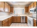 Traditional kitchen with stainless steel appliances, wood cabinets, and white countertops offering a functional design at 10815 N 117Th Pl, Scottsdale, AZ 85259