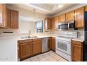 Well-lit kitchen featuring stainless steel appliances, wood cabinetry, and neutral countertops for a classic look at 10815 N 117Th Pl, Scottsdale, AZ 85259