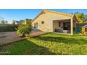 Well-maintained backyard featuring a lush green lawn, covered patio with ample space for outdoor seating at 12947 W Mauna Loa Ln, El Mirage, AZ 85335