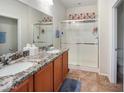 Bathroom featuring double sinks, granite countertops, and glass enclosed walk-in shower at 17542 W Pinnacle Vista Dr, Surprise, AZ 85387