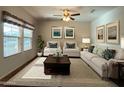 Living room with large windows, neutral-toned furniture, decorative pillows, and a patterned rug at 17542 W Pinnacle Vista Dr, Surprise, AZ 85387