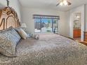 Sun-drenched main bedroom with a decorative headboard, plush bedding, and a view of the tranquil backyard at 17542 W Pinnacle Vista Dr, Surprise, AZ 85387