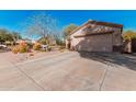 Single-story home featuring a two-car garage and low-maintenance desert landscaping at 17634 W Hearn Rd, Surprise, AZ 85388