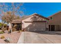 Charming single-story home featuring a two-car garage and desert landscaping with cacti and drought-tolerant plants at 17634 W Hearn Rd, Surprise, AZ 85388