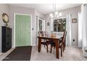 Cozy dining room with a wood table, chandelier lighting, and a striking green door at 1825 W Ray Rd # 2116, Chandler, AZ 85224