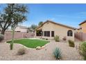 Private backyard oasis with artificial turf, desert landscaping, and a covered patio for outdoor enjoyment at 2416 E Cielo Grande Ave, Phoenix, AZ 85024