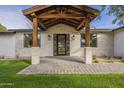 Inviting front entrance with a covered porch, stone columns, and a glass front door at 2902 E Pierson St, Phoenix, AZ 85016