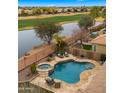 Aerial view showcasing a backyard pool and spa overlooking a serene lake and a verdant golf course at 3400 E Isaiah Ave, Gilbert, AZ 85298