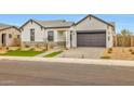 Attractive single-story home with a paved driveway, xeriscaping, and neutral color palette at 34315 N Sandpiper Trl, Queen Creek, AZ 85144