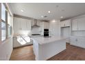 Modern kitchen boasts white cabinetry, stainless steel appliances and a large center island at 4069 W Nora Dr, San Tan Valley, AZ 85144