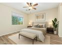 Cozy bedroom showcasing a neutral color scheme, plush bedding, ceiling fan and ample natural light at 42906 W Darter Dr, Maricopa, AZ 85138
