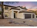 Charming home exterior featuring a rock-lined landscape, inviting entrance, and three-car garage at 5210 E Danbury Rd, Scottsdale, AZ 85254