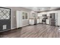 Spacious kitchen with stainless steel appliances, white cabinets, and wood-look flooring at 6507 N 44Th Ave, Glendale, AZ 85301