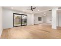 Bright living room features hardwood floors, sliding glass doors to the backyard, and modern ceiling fan at 8252 E Heatherbrae Ave, Scottsdale, AZ 85251