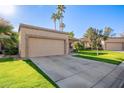 Charming single-story home with a two-car garage, well-manicured lawn, and sunny Arizona skies at 9329 W Topeka Dr, Peoria, AZ 85382