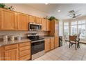 Bright kitchen with stainless steel appliances, granite countertops, wood cabinets, and an adjacent breakfast nook at 10332 W Potter Dr, Peoria, AZ 85382