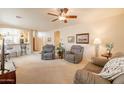 Spacious living room featuring neutral walls, plush carpeting, ceiling fan and two comfortable armchairs at 10332 W Potter Dr, Peoria, AZ 85382