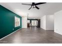 Spacious living room with stylish gray tile flooring, ceiling fan, and green accent wall at 10704 E Plata Ave, Mesa, AZ 85212