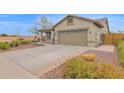 Side view of a house with a large driveway and mature landscaping at 11305 W Monte Vista Rd, Avondale, AZ 85392