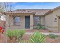 Inviting entrance to a tan single-story house with desert landscaping at 11305 W Monte Vista Rd, Avondale, AZ 85392