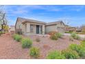 Landscaped front yard with mature plants and shrubs leading to a tan single-story house at 11305 W Monte Vista Rd, Avondale, AZ 85392