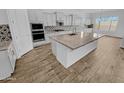 Modern kitchen featuring white cabinets, a large island with a light countertop, and updated appliances at 12858 W Pasaro Dr, Peoria, AZ 85383