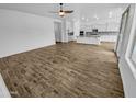 Bright living room showcasing wood-look floors, neutral walls, and a view into the open-concept kitchen at 12858 W Pasaro Dr, Peoria, AZ 85383