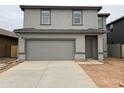 A modern two-story home with a neutral color scheme, two-car garage, and a freshly paved driveway at 13170 E Verbina Ln, Florence, AZ 85132