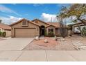 Charming single-story home with desert landscaping, a two car garage, and a terracotta tiled roof at 14404 N 56Th Pl, Scottsdale, AZ 85254