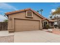 Single-story home featuring a two-car garage, desert landscaping and a terracotta tiled roof at 14404 N 56Th Pl, Scottsdale, AZ 85254