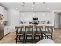 Modern kitchen with white cabinets, granite countertops, stainless steel appliances, and pendant lighting at 17055 W El Caminito Dr, Waddell, AZ 85355