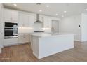 Bright kitchen featuring white cabinets, a center island, stainless steel appliances, and stylish backsplash at 18432 W Mohave St, Goodyear, AZ 85338