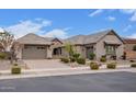 Charming home featuring a three-car garage, stone accents, tiled roof, and easy to maintain front yard at 19318 E Walnut Rd, Queen Creek, AZ 85142