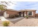 A well-maintained home with a landscaped front yard, featuring rock ground cover and mature shrubs at 20212 N Valencia Dr, Maricopa, AZ 85138