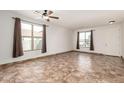 Spacious living room featuring tile flooring, neutral walls, and two large windows for natural light at 20212 N Valencia Dr, Maricopa, AZ 85138