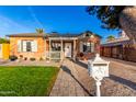 Inviting front yard with a brick walkway and lush green lawn leading to a charming brick home with a cozy porch at 2201 N 17Th Ave, Phoenix, AZ 85007