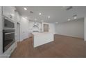 Bright, open kitchen featuring sleek white cabinetry and stainless steel appliances at 24192 W Agora Ln, Buckeye, AZ 85326